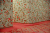A 35mm film photograph of a corner in the Hotel Okura South Wing featuring vintage floral wallpaper, a pink patterned carpet, and a retro brass light switch.